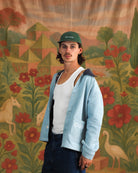Model wearing light blue denim-style Jarana jacket with white floral embroidery and contrast collar