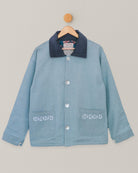 Front view of embroidered denim jacket with floral blockprint lining, hanging on wooden hanger