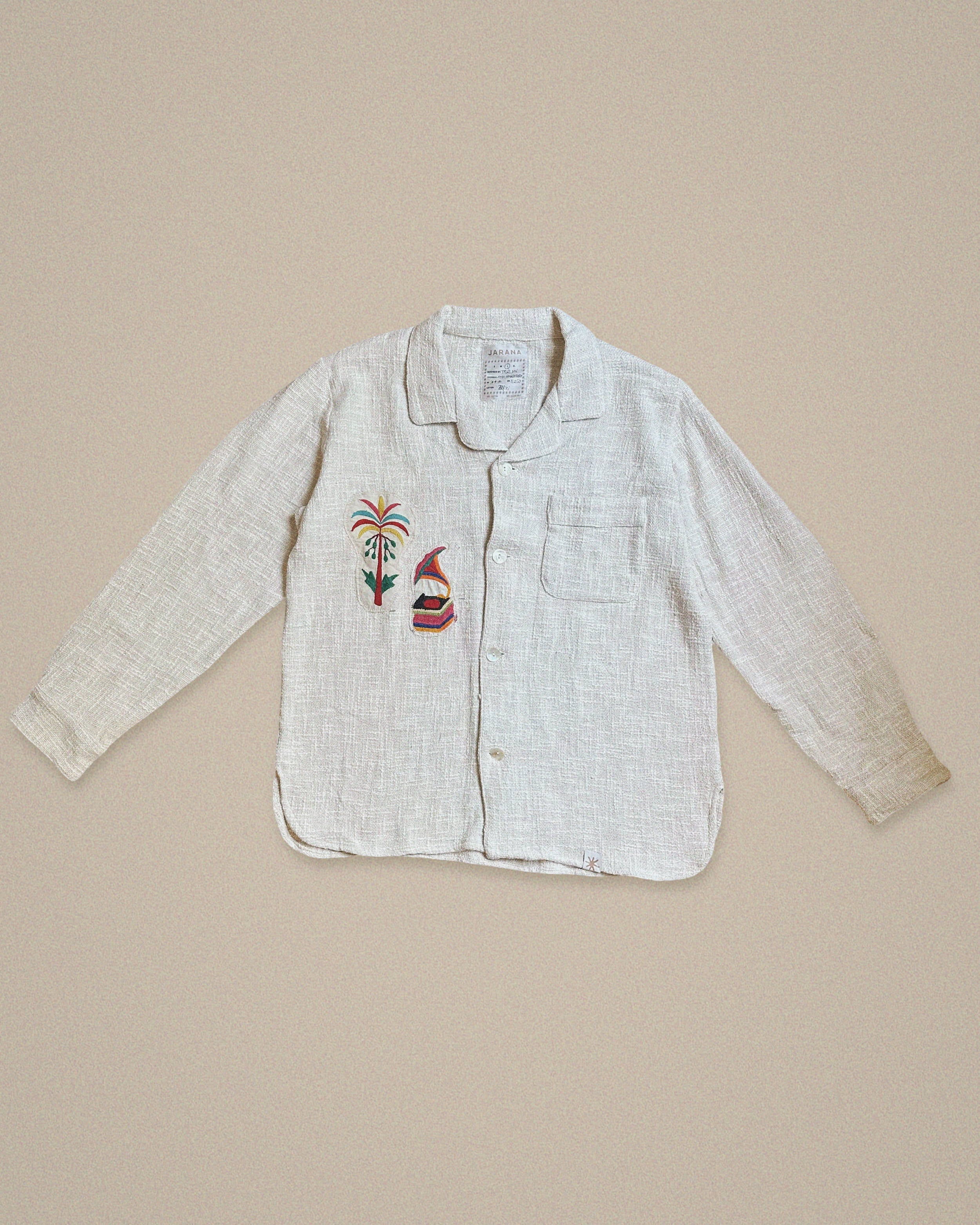 Handmade linen shirt with colorful palm tree and musical figure embroidery β playful Indian motif by Jarana