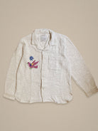 Handmade cotton shirt with purple and green bird embroidery flying beneath a blue starburst β Jarana limited edition