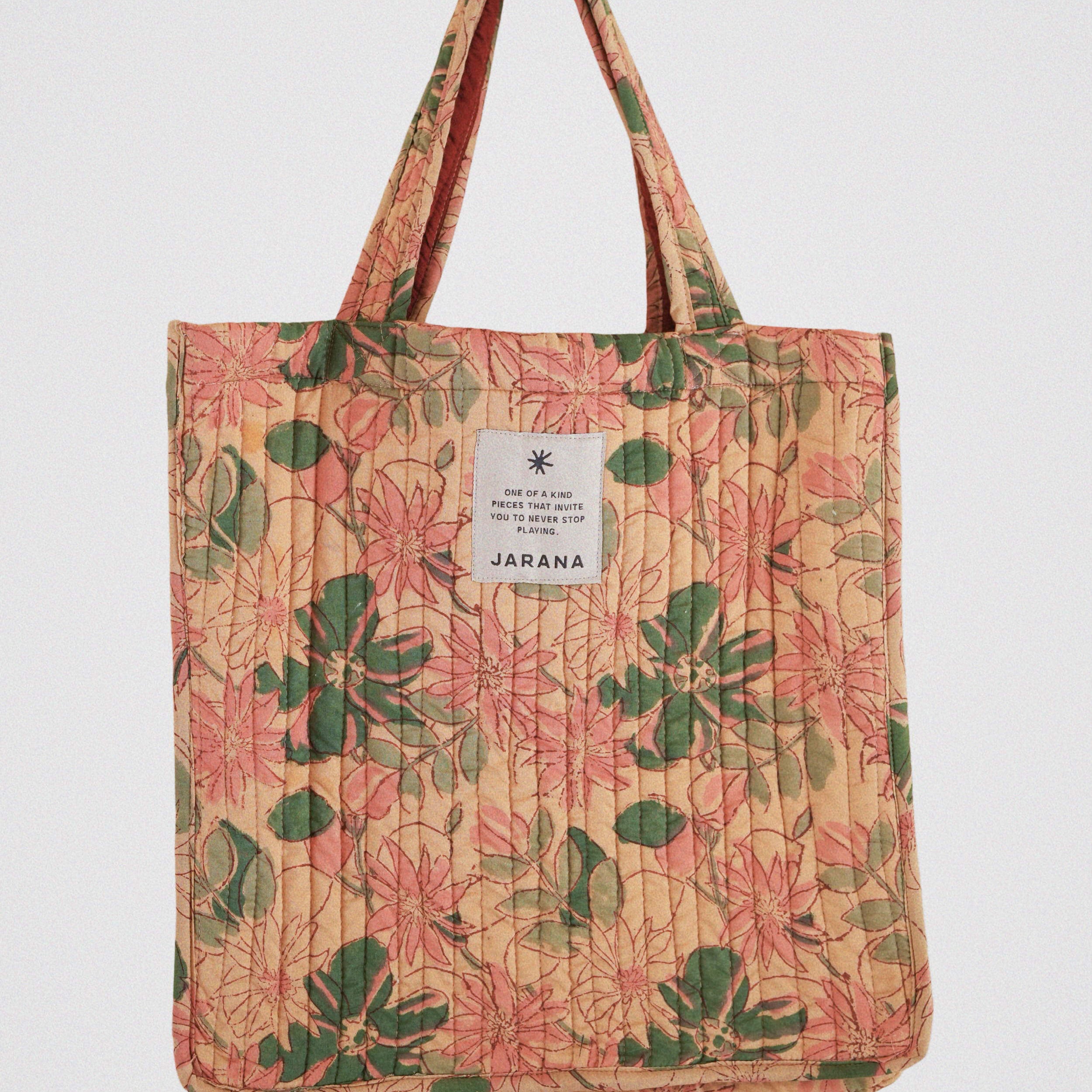 Peach-toned quilted tote bag featuring vintage floral block print in green and pink, handcrafted in India by Jarana.