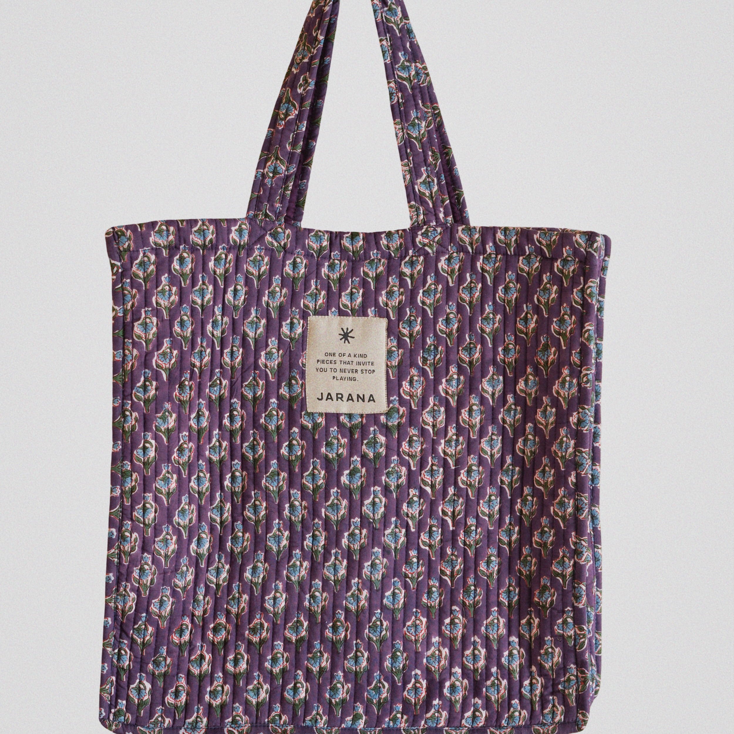 Jarana quilted tote bag in violet with delicate floral block print, crafted from natural cotton with inner pocket and signature label.