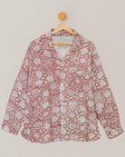 Full front view of a handcrafted Kantha shirt with red and white floral embroidery, hanging on wooden hanger