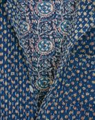 Close-up of blue fabric with fine Kantha embroidery and small traditional block-printed floral motifs