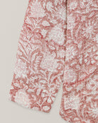 Close-up of shirt sleeve and hem with traditional floral Kantha embroidery on red cotton fabric