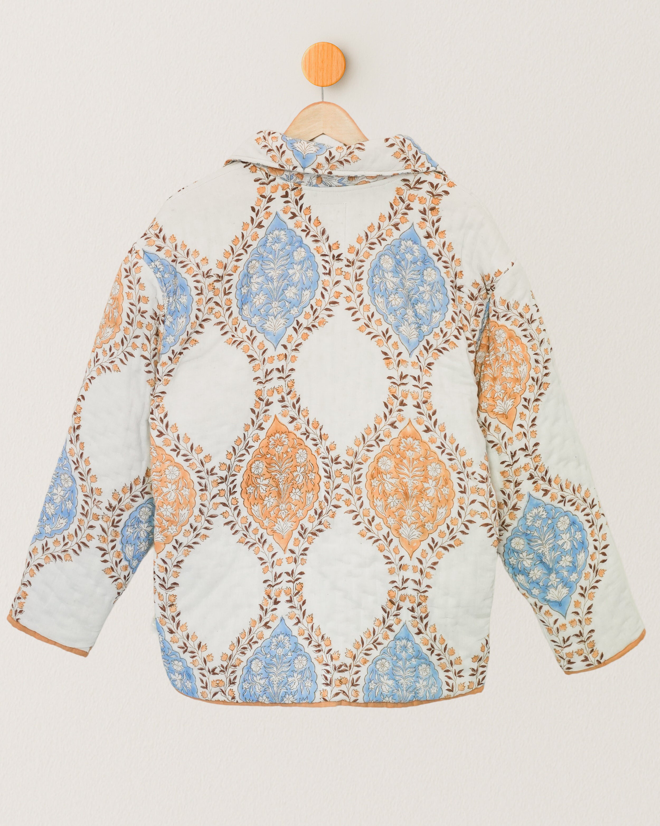 Back view of cotton quilted jacket with symmetrical orange and blue floral blockprint layout