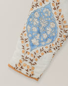 Close-up of quilted sleeve featuring blue floral blockprint motif with tan and brown leaf accents