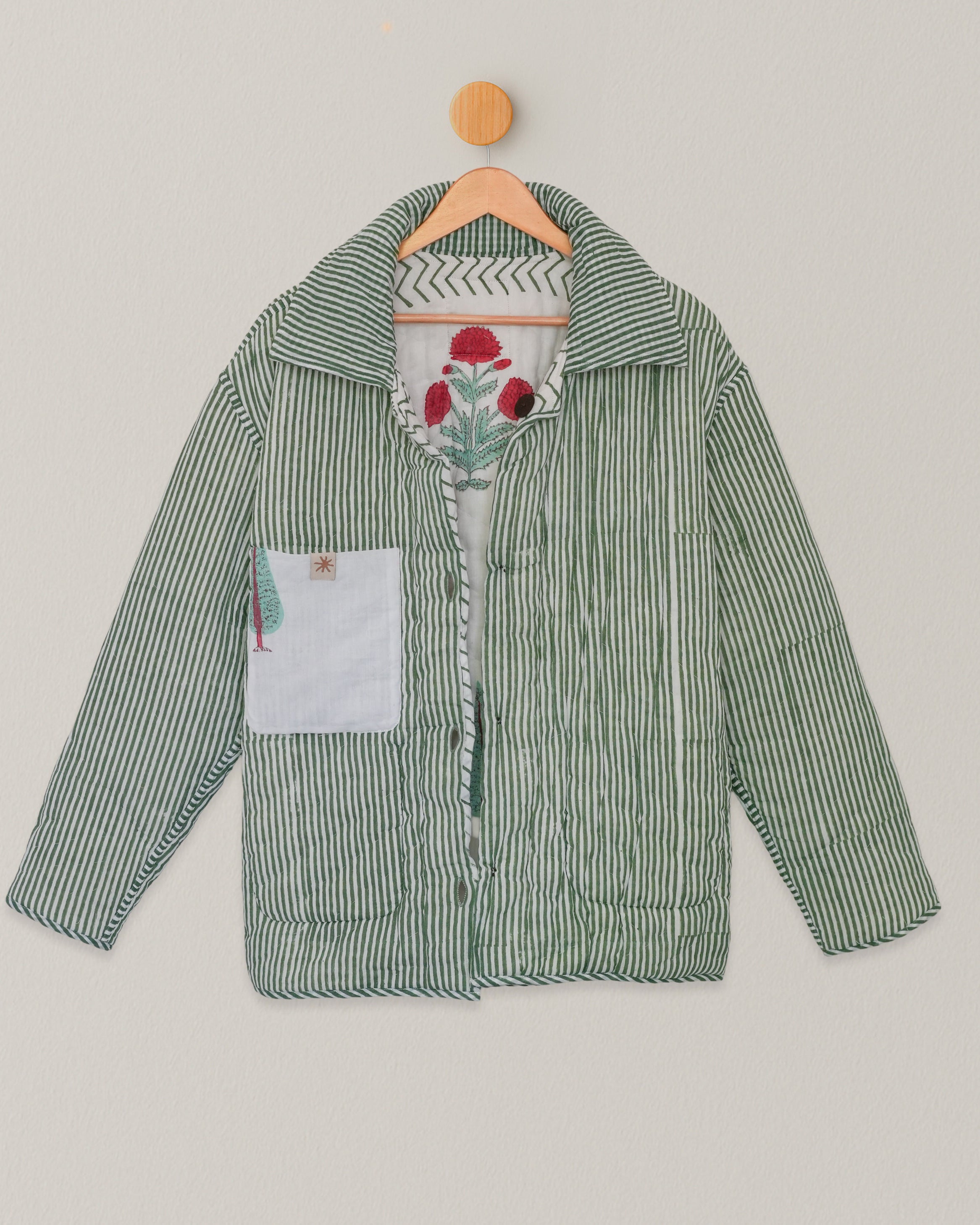 Back view of reversible hand blockprinted quilted jacket with vertical green stripes and interior
