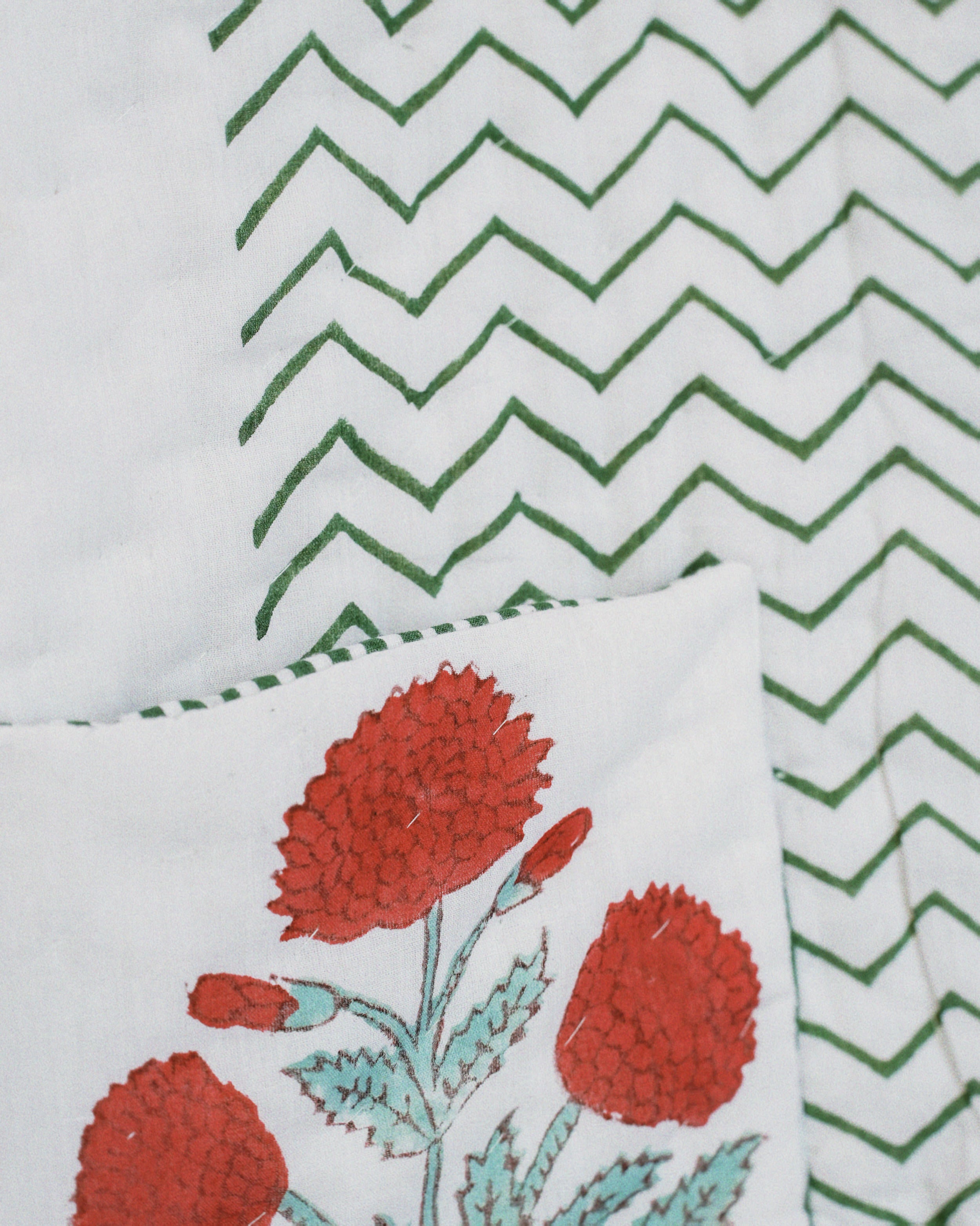 Textile with red floral design and green zigzag pattern