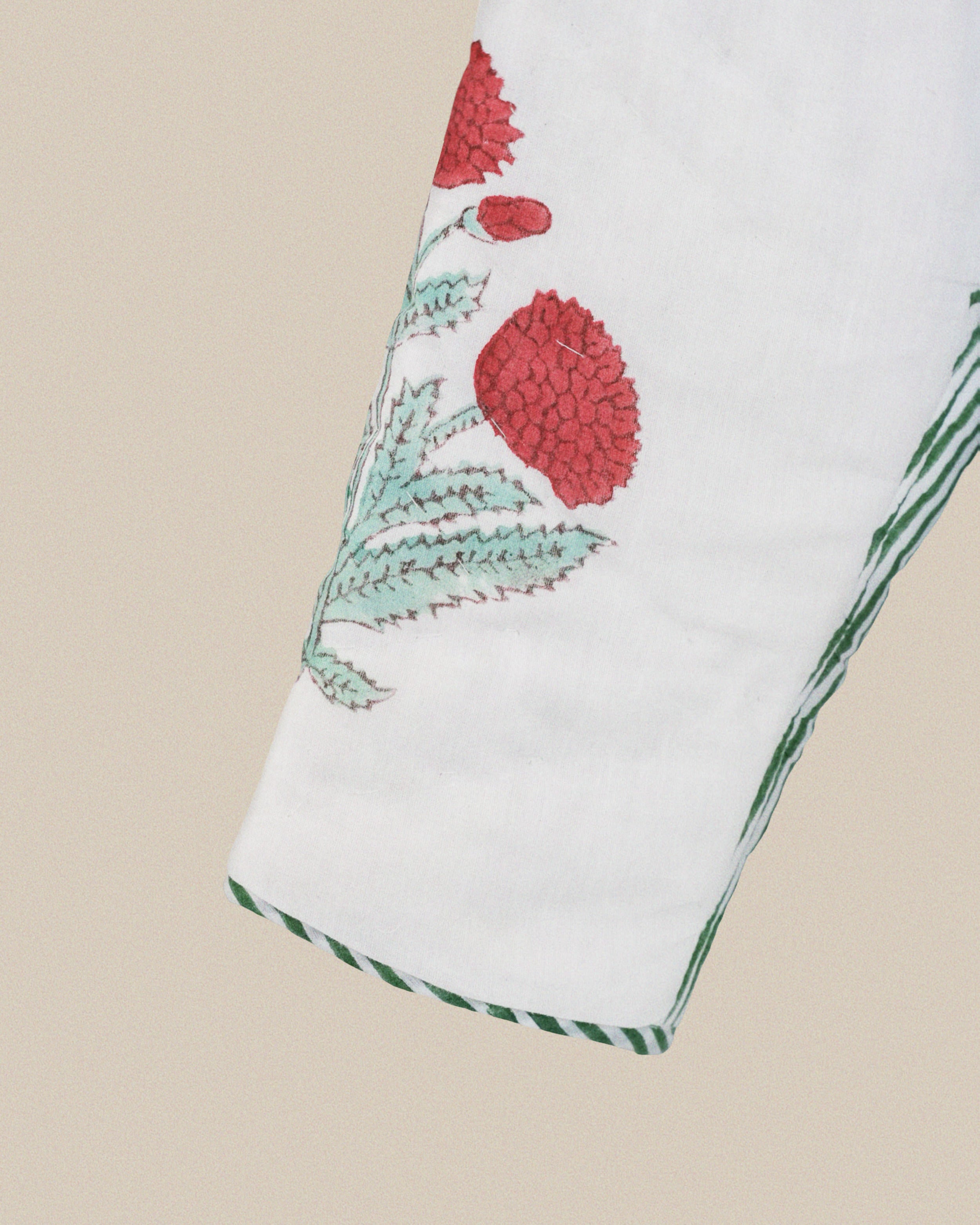 White napkin with red floral design on a beige background