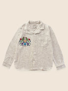 Embroidered shirt with a colorful design on a beige background