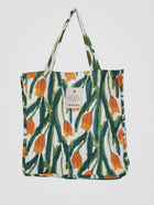 Vibrant quilted tote bag with hand-printed abstract floral design in green, orange, and blue, crafted from natural cotton.