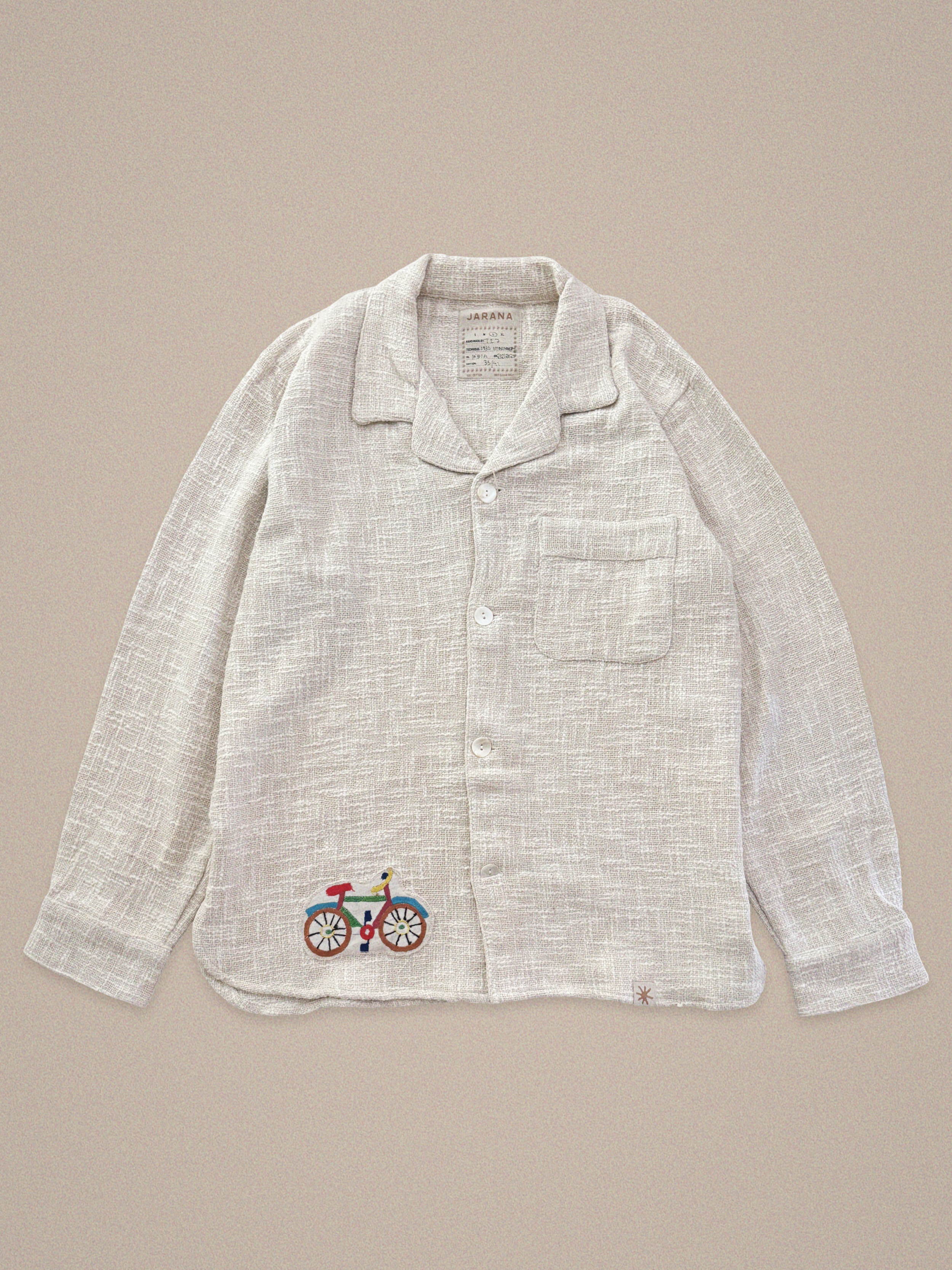 Handmade linen shirt with bicycle embroidery – playful detail on light textile by Jarana