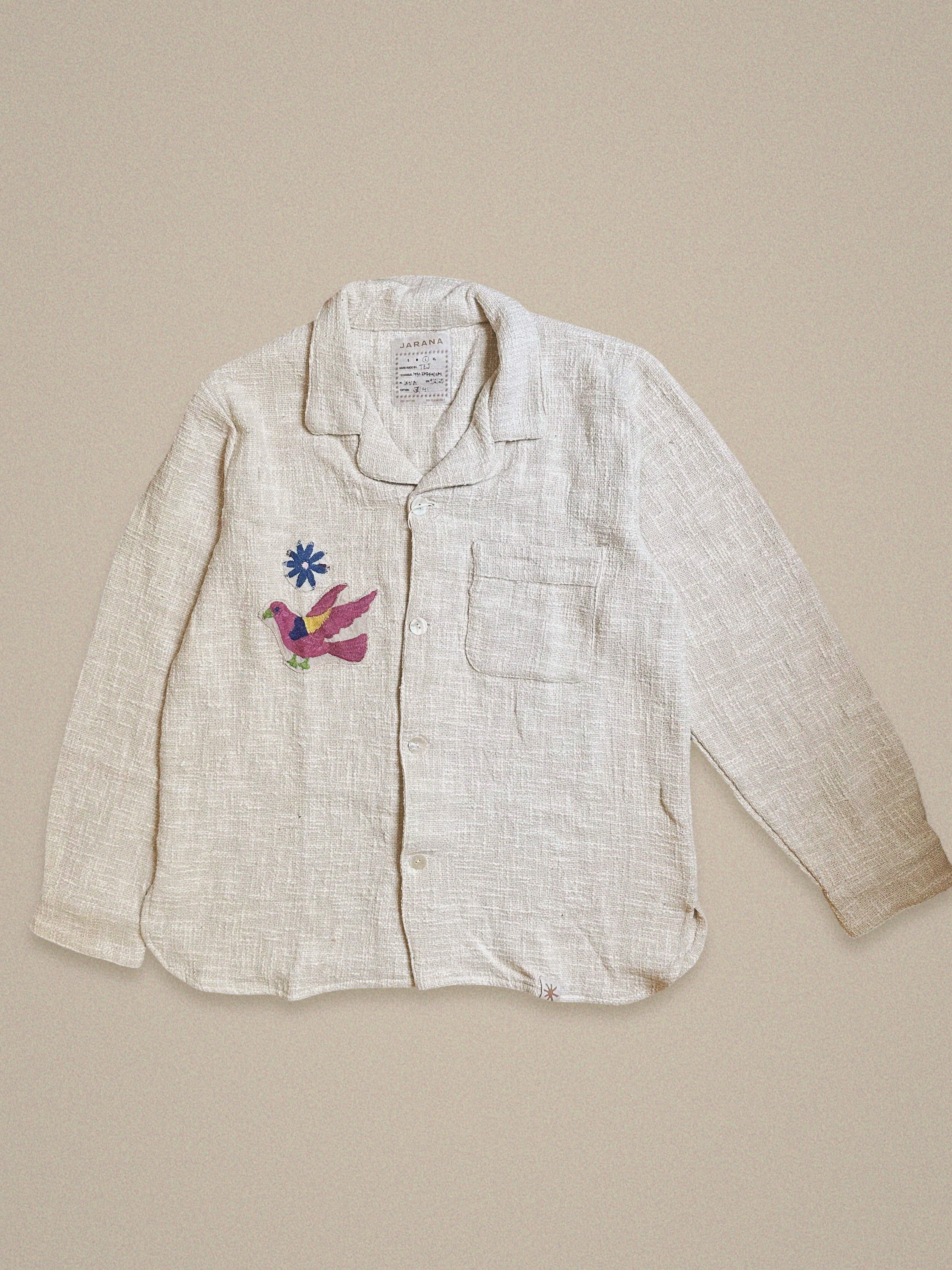 Handmade cotton shirt with purple and green bird embroidery flying beneath a blue starburst – Jarana limited edition