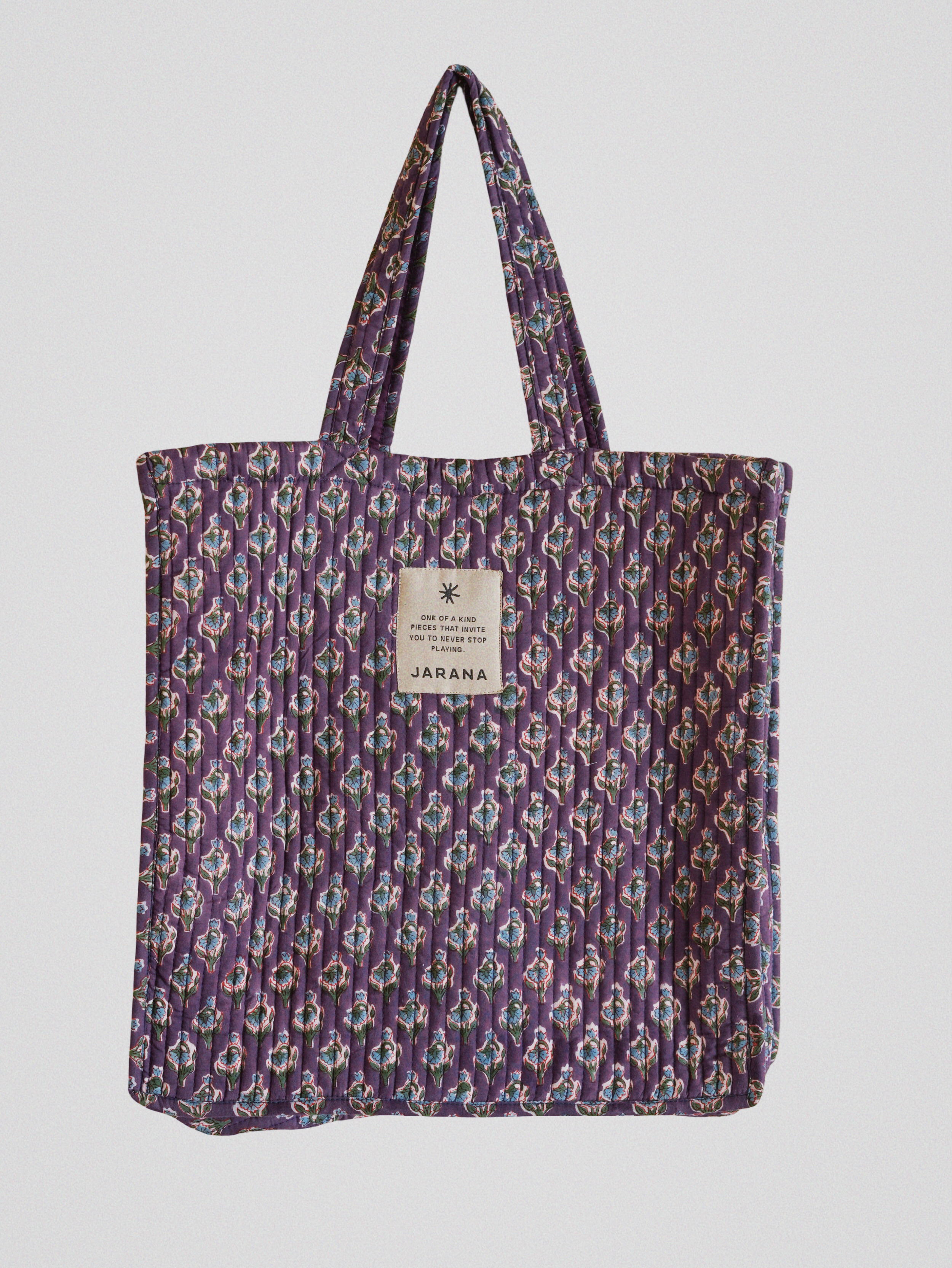 Jarana quilted tote bag in violet with delicate floral block print, crafted from natural cotton with inner pocket and signature label.
