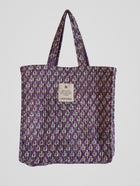 Jarana quilted tote bag in violet with delicate floral block print, crafted from natural cotton with inner pocket and signature label.