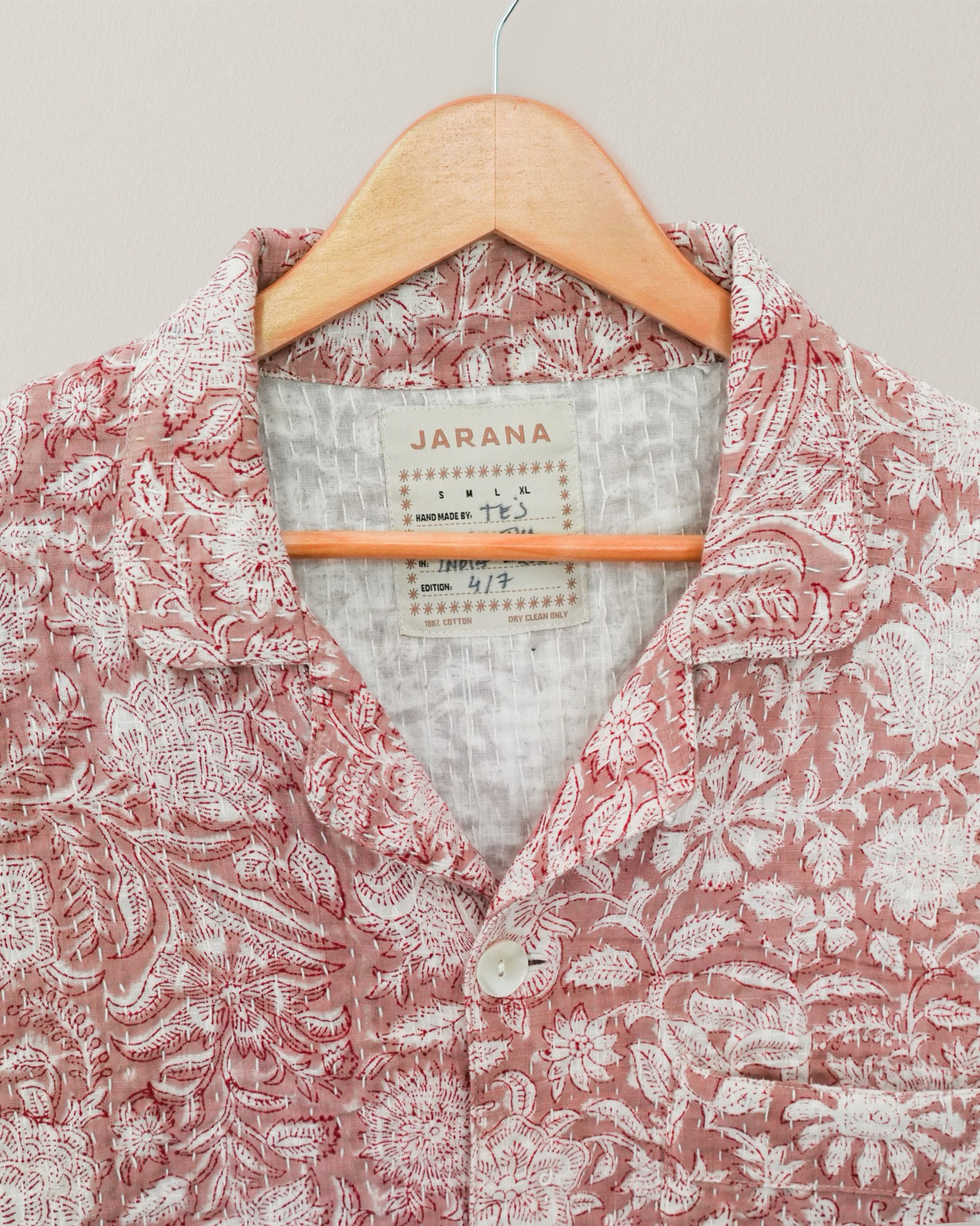 Detail of shirt collar and label reading “Jarana,” showcasing intricate Kantha stitching and fabric texture