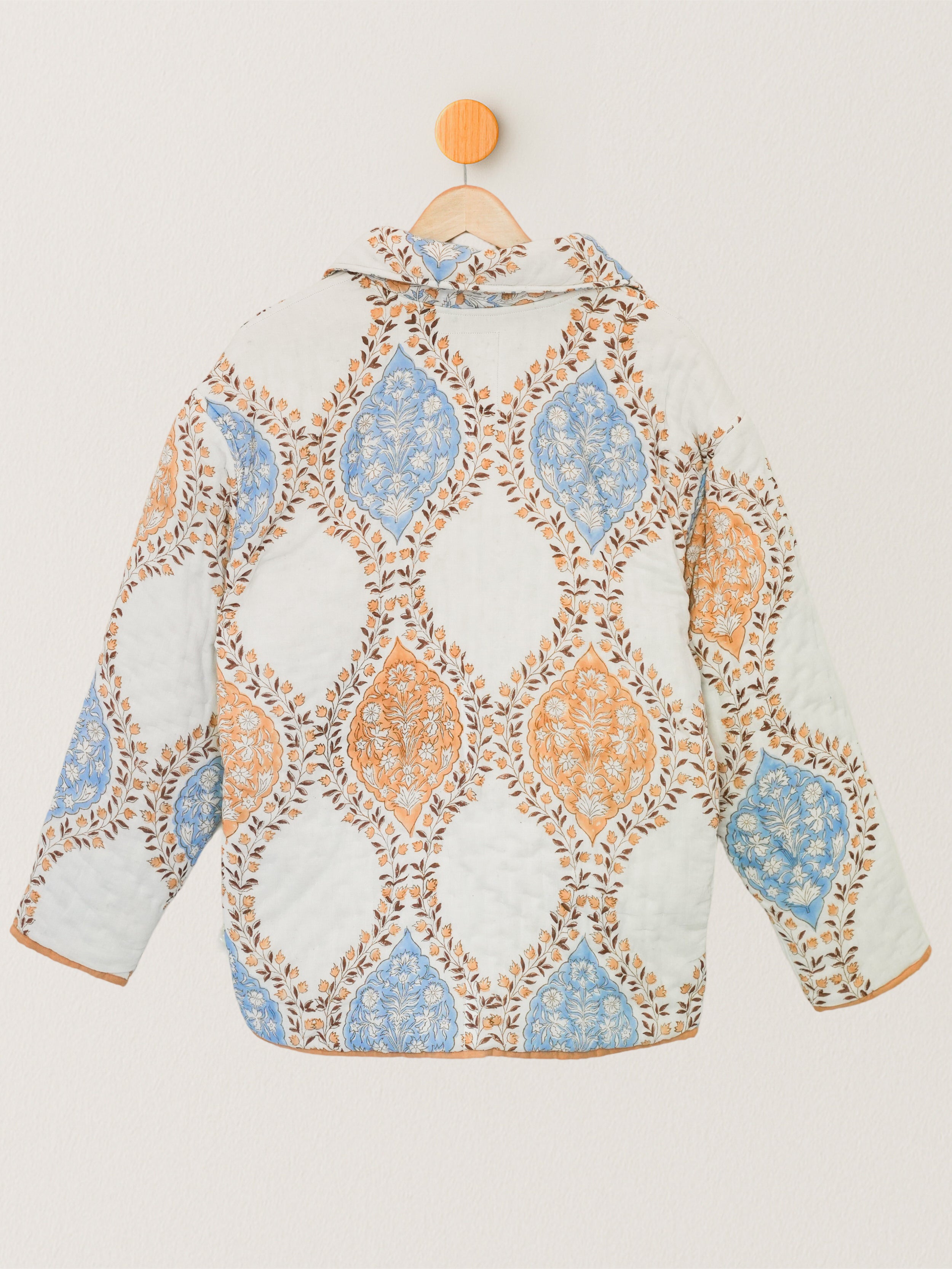 Back view of cotton quilted jacket with symmetrical orange and blue floral blockprint layout