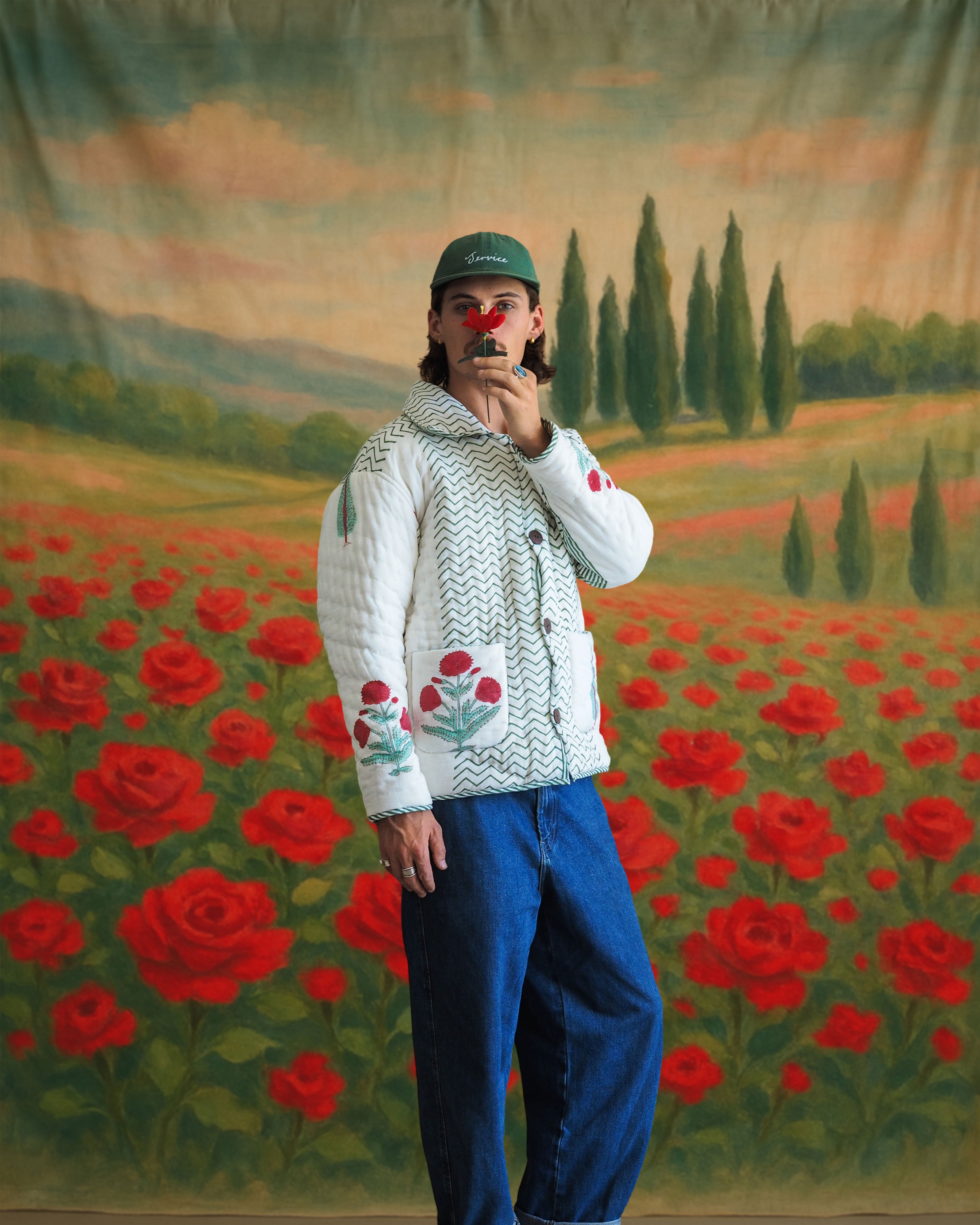 Model in front view wearing a cotton quilted jacket with blockprint zigzag pattern and floral embroidery