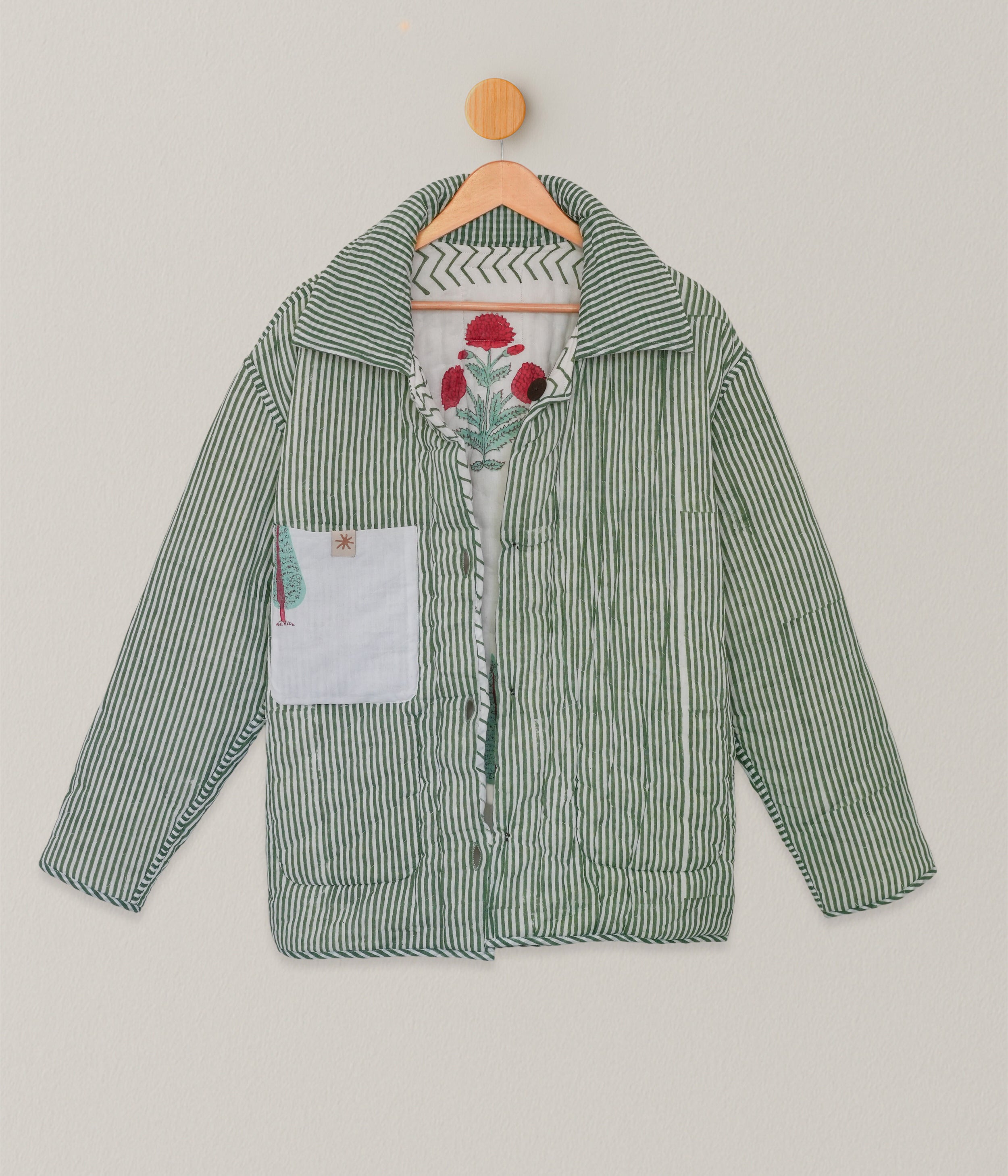 Back view of reversible hand blockprinted quilted jacket with vertical green stripes and interior