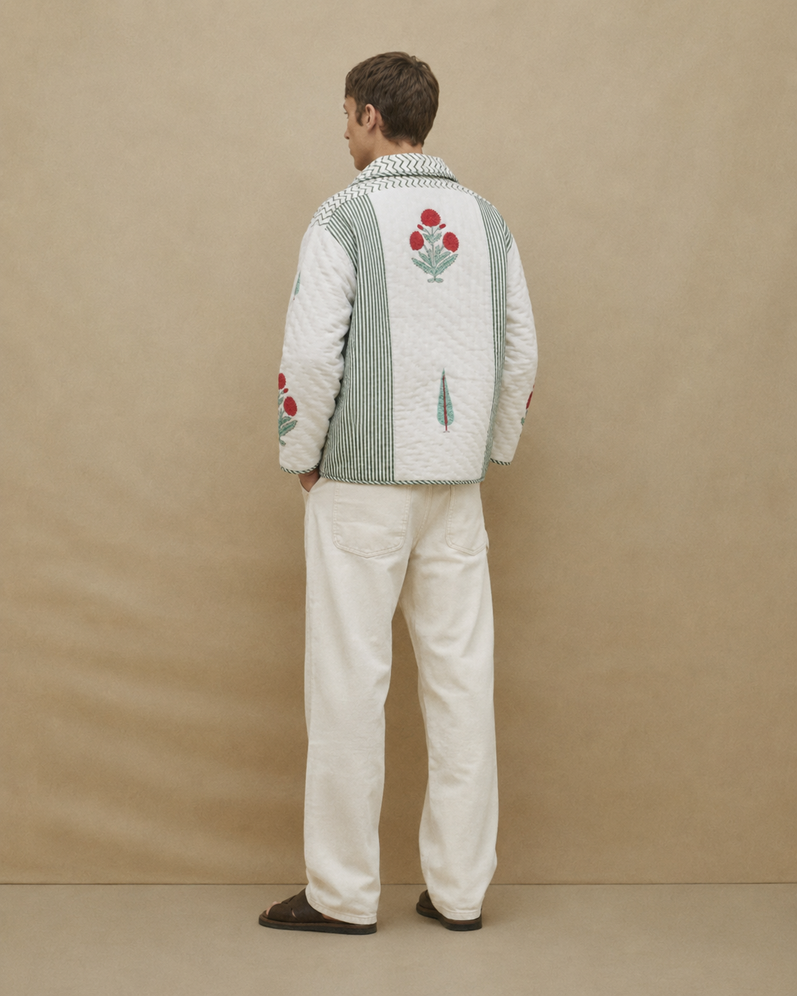 Person wearing a patterned sweater with floral designs on a beige background