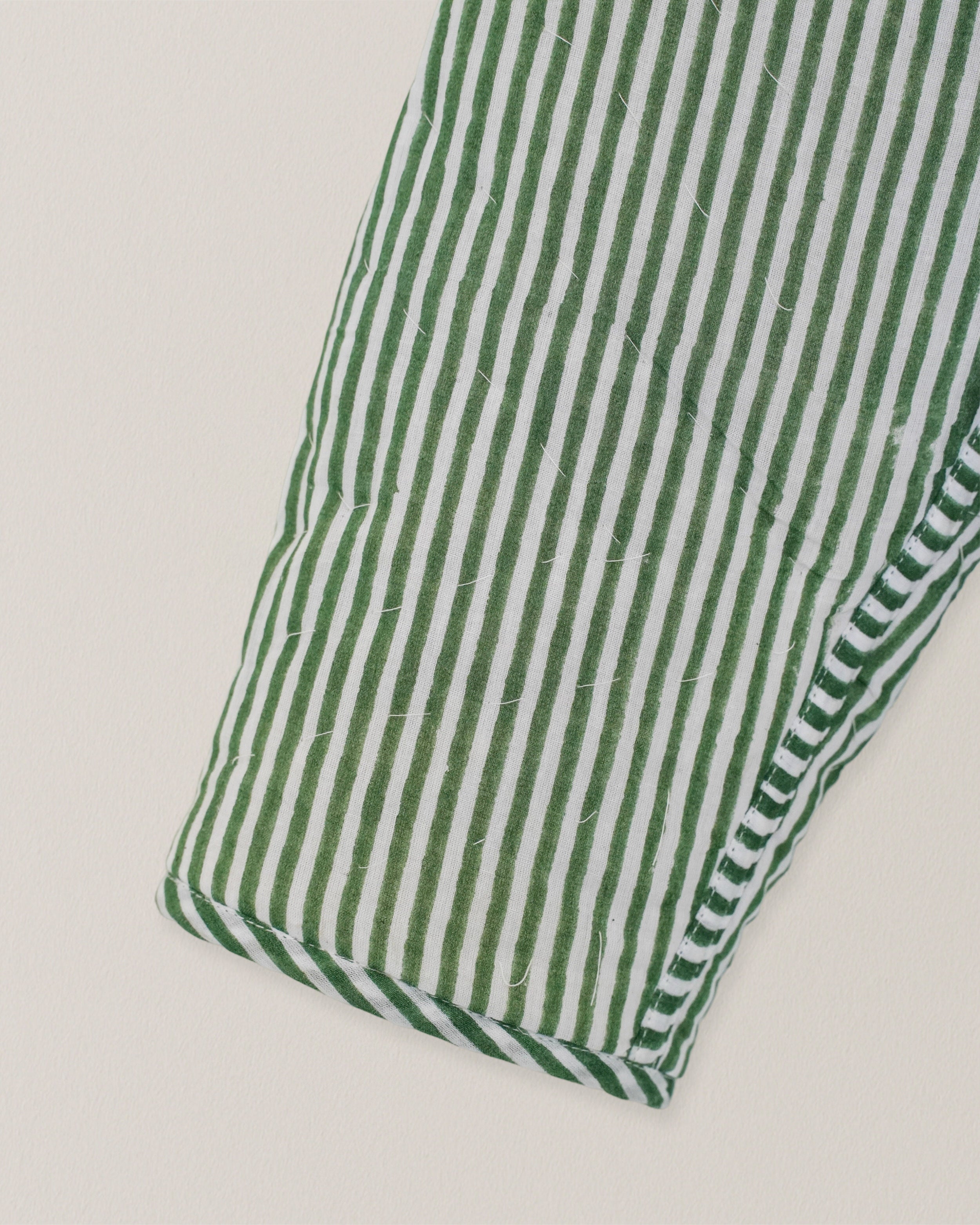 Detail of green and white striped cotton sleeve from a quilted reversible jacket with blockprinted texture